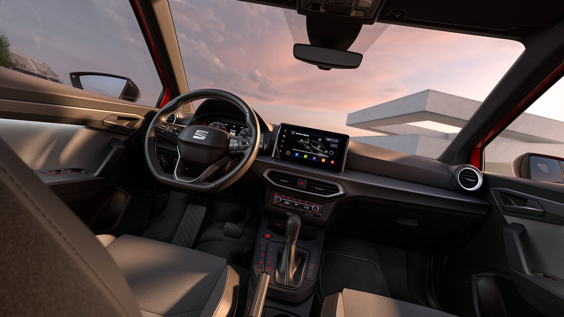 Innenraum eines SEAT Arona bei Sonnenuntergang. Blick vom Rücksitz auf das Lenkrad mit Logo, das Armaturenbrett mit Touchscreen-Display und die Mittelkonsole mit Schalthebel. Beifahrersitz und Seitenfenster sichtbar Innenraum eines SEAT Arona bei Sonnenuntergang. Blick vom Rücksitz auf das Lenkrad mit Logo, das Armaturenbrett mit Touchscreen-Display und die Mittelkonsole mit Schalthebel. Beifahrersitz und Seitenfenster sichtbar