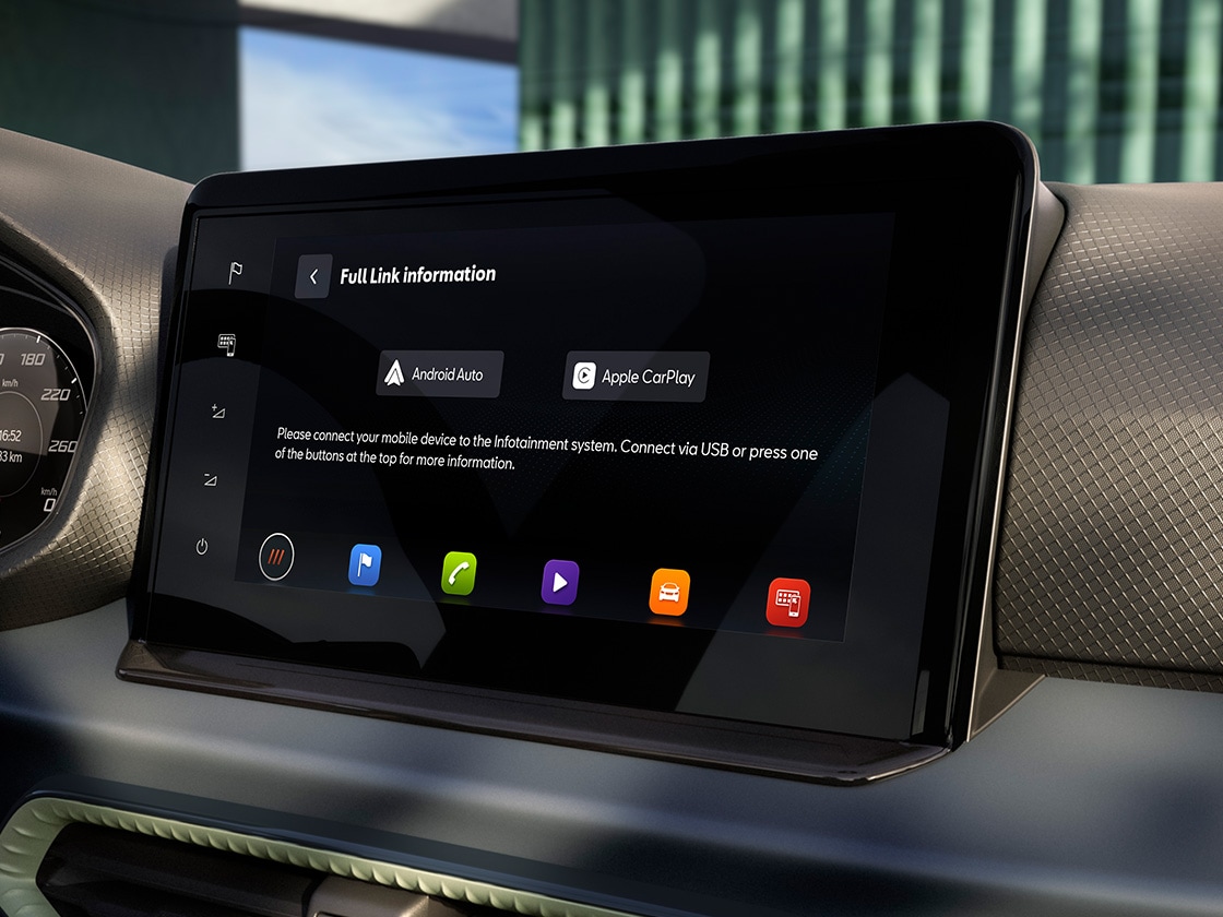 Touchscreen-Infotainmentsystem im SEAT Arona mit Android Auto und Apple CarPlay, links neben dem Bildschirm ein Tacho mit Geschwindigkeitsanzeige. Die Textur des Armaturenbretts ist sichtbar.
