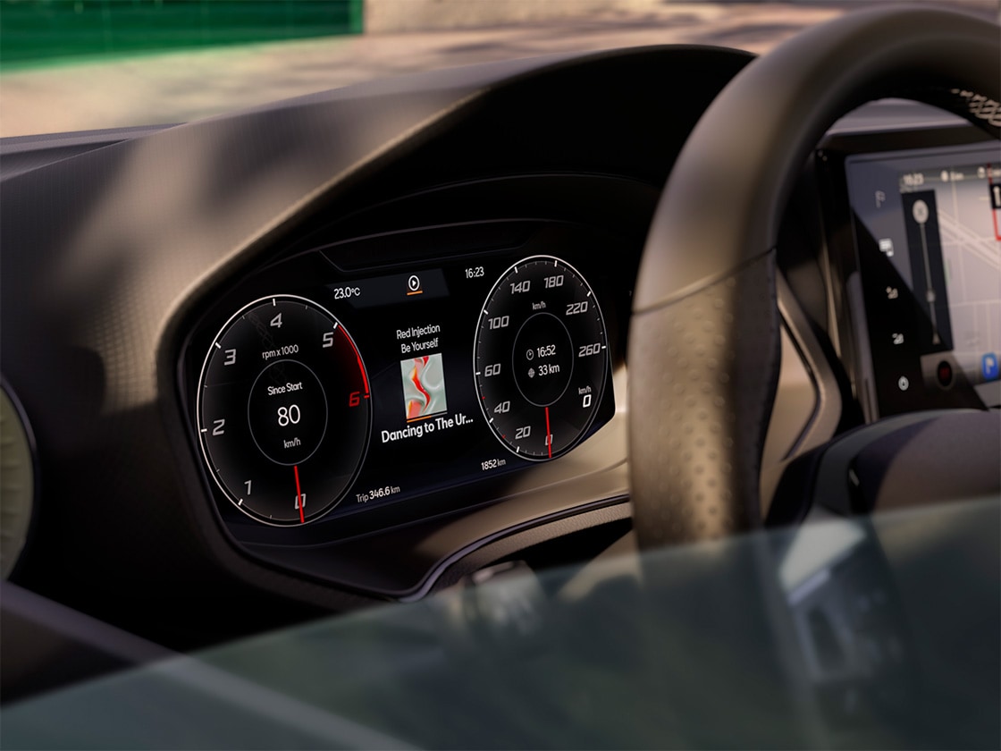 Digitale Instrumententafel in einem Auto zeigt Geschwindigkeit von 80 km/h, Außentemperatur, Uhrzeit und Songtitel. Teile des Lenkrads und ein weiteres Display mit Navigationsansicht sind sichtbar.