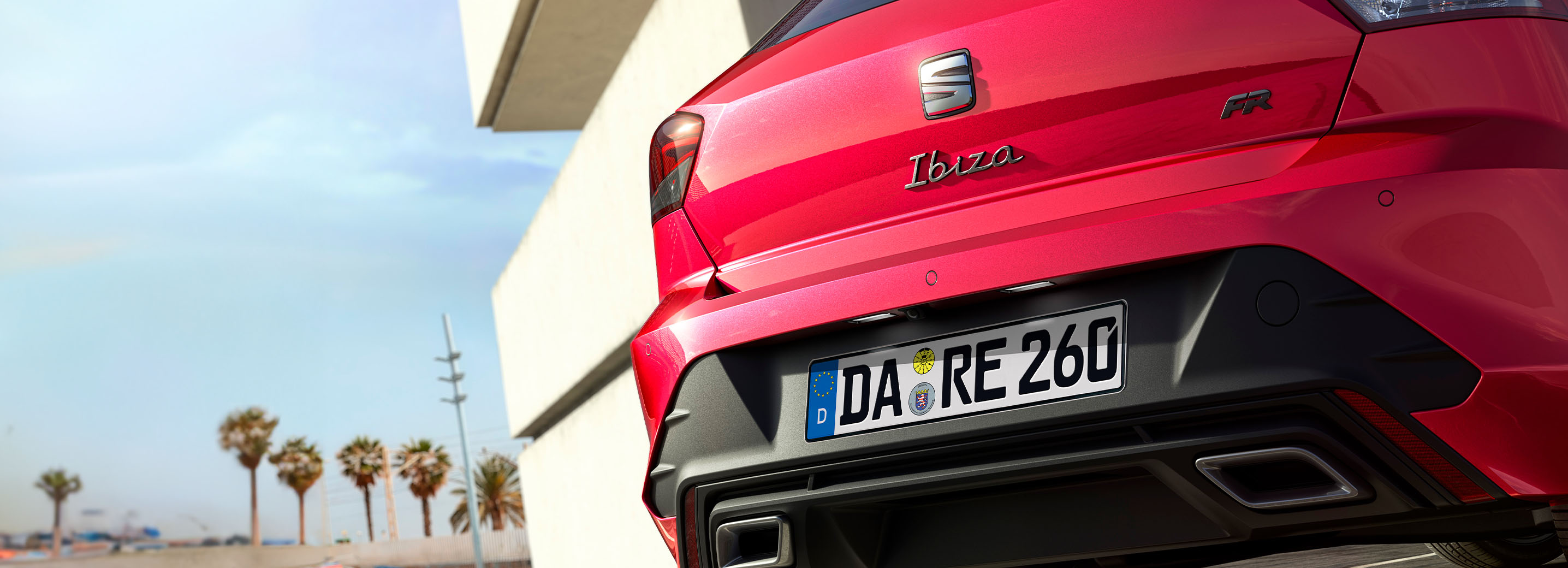 Rote Heckansicht eines SEAT Ibiza mit Kennzeichen DA RE 260. Sichtbar sind das Ibiza-Emblem, der Schriftzug FR und das SEAT-Logo. Im Hintergrund ein modernes Gebäude und ein blauer Himmel.