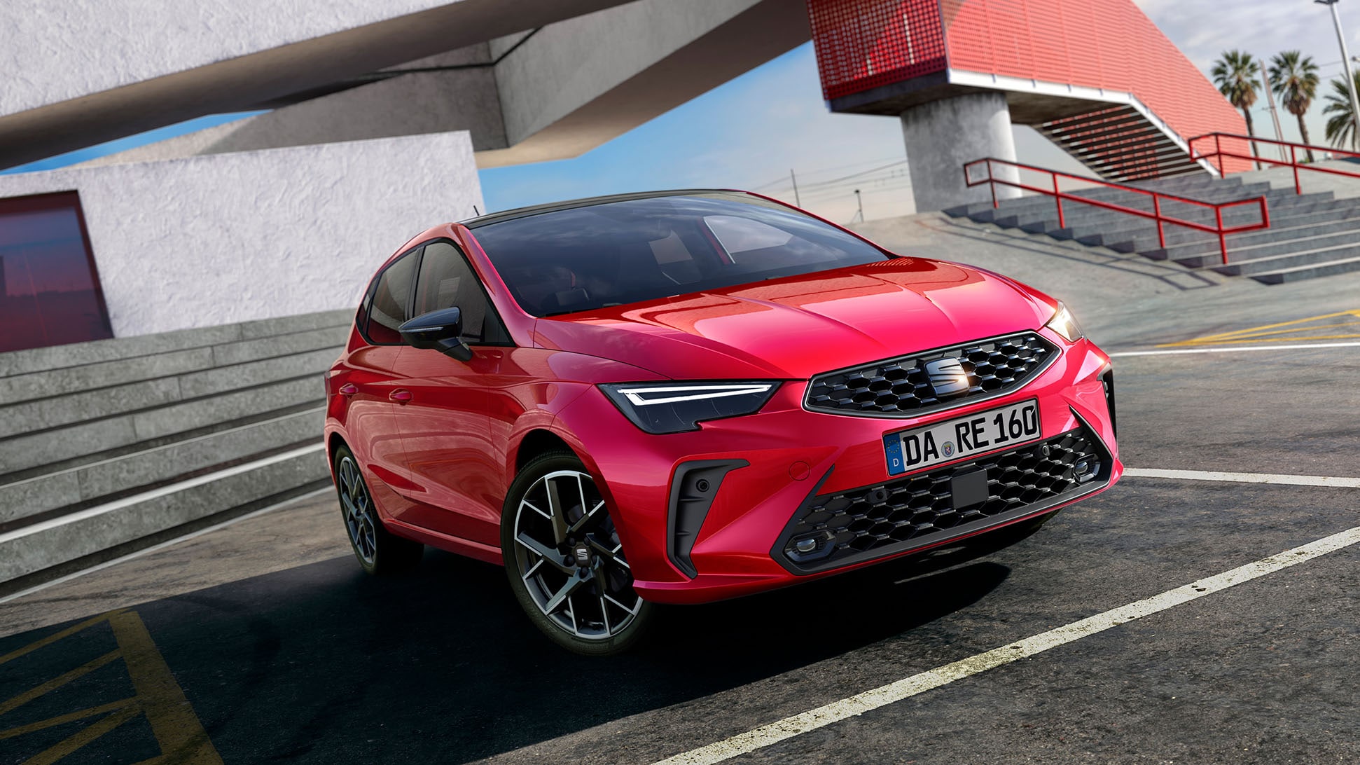 Roter SEAT Ibiza von schräg vorn, Parkposition auf Asphaltfläche vor moderner Architektur mit roten Akzenten. Beleuchtete Frontscheinwerfer, deutlich sichtbarer Kühlergrill und Kennzeichen DA RE 160 Klarer Himmel im Hintergrund Roter SEAT Ibiza von schräg vorn, Parkposition auf Asphaltfläche vor moderner Architektur mit roten Akzenten. Beleuchtete Frontscheinwerfer, deutlich sichtbarer Kühlergrill und Kennzeichen DA RE 160 Klarer Himmel im Hintergrund