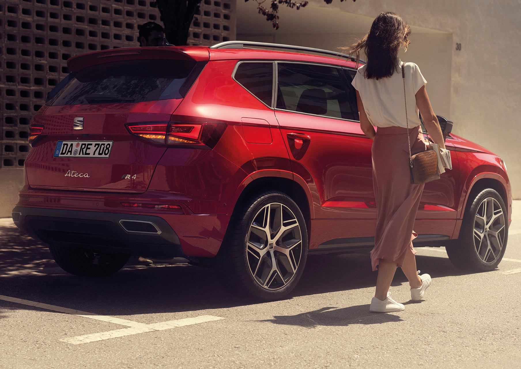 woman-walking-next-to-seat-ateca-velvet-red-colour