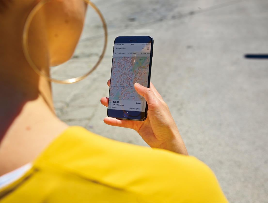 Frau die Smartphone in der Hand hält und sich über die App die Fernzugrifffunktion benutzt