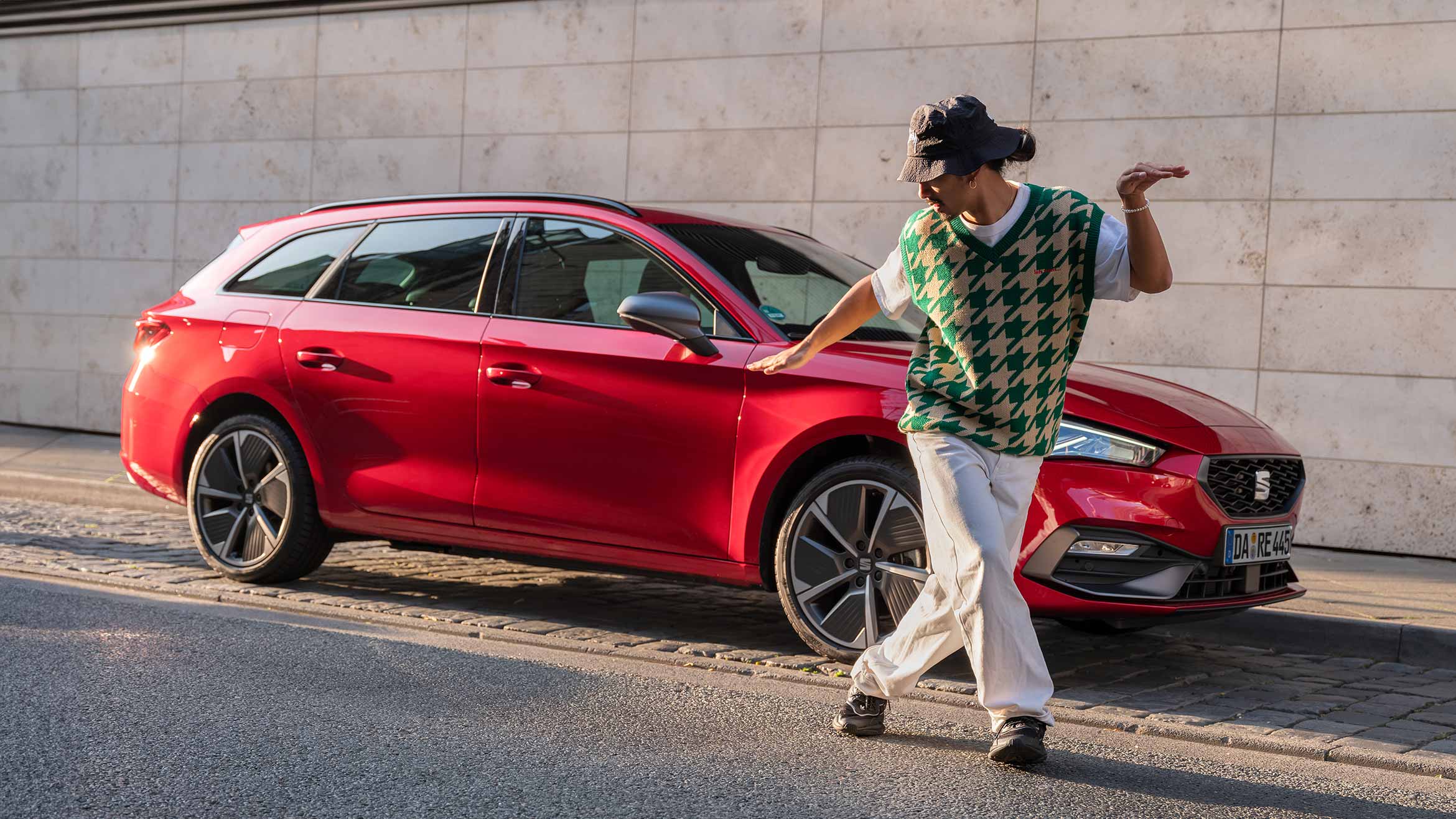 man dancing in front of red seat leon sportstourer