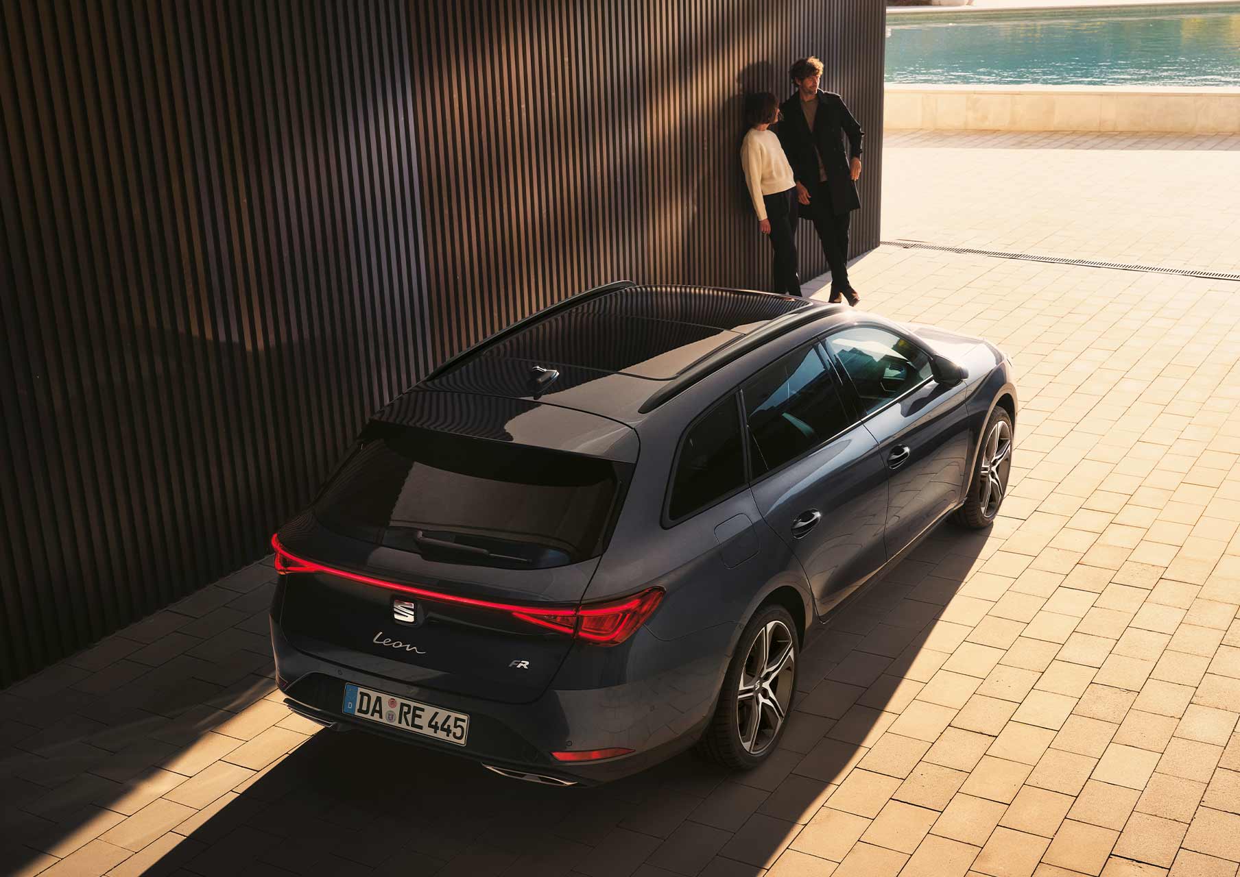 Pärchen schaut auf Seat Leon Sportstourer Magnetic Tech Farbe mit Coast to Coast Lights