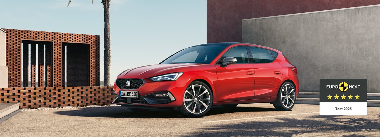 Ein roter SEAT Leon steht auf einem öffentlichen Parkplatz.