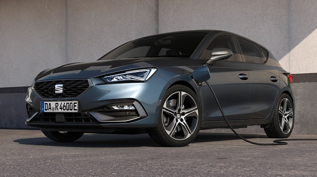 Seat leon in blue charging via wall charger, stairs, low angle