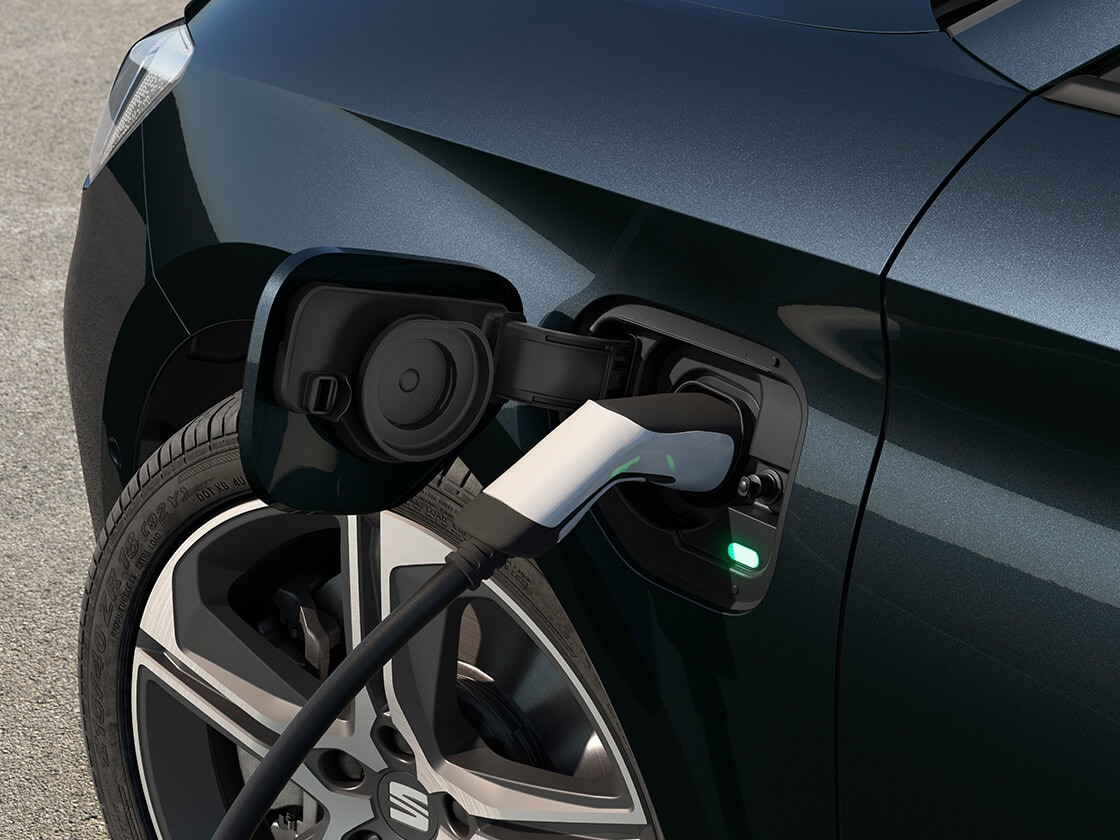 Rückansicht eines Seat Leon FR mit Automatikgetriebe beim Laden an einer Ladestation, ein neues Fließheckmodell für 2025 in Magnetgrau, komplett mit Parksensoren hinten und LED-Scheinwerfern und -Rückleuchten.