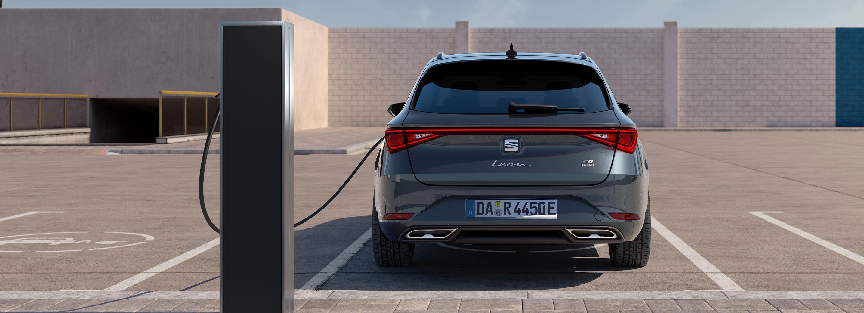 Ein grauer SEAT Leon steht an einer öffentlichen Ladesäule und lädt seine Batterie auf.
