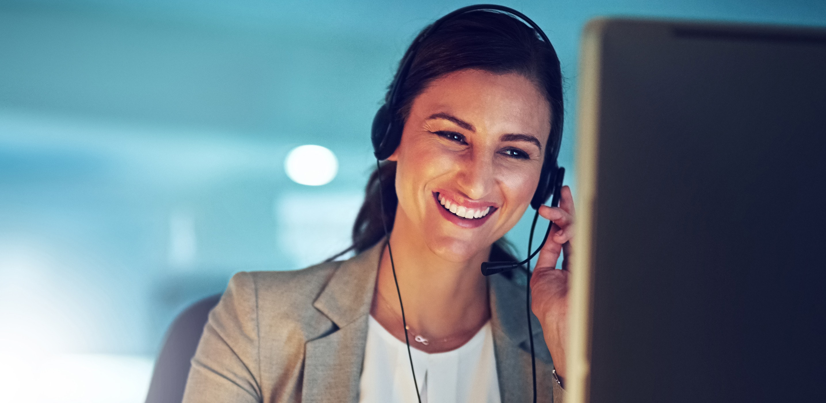 Lachende Frau mit Headset am Monitor | SEAT