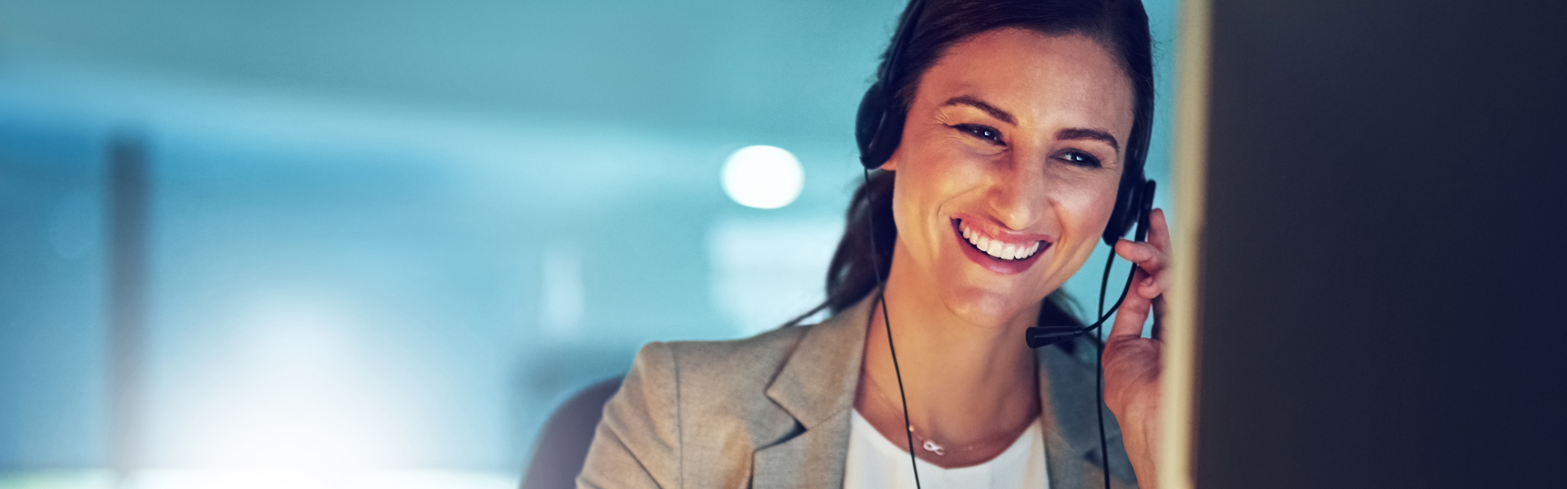 Lachende Frau mit Headset am Monitor | SEAT