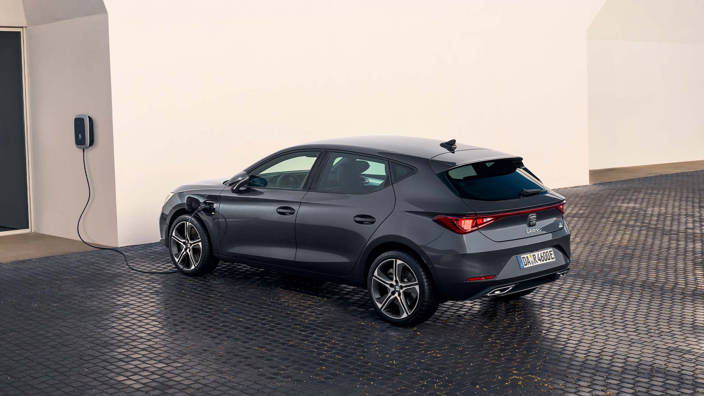 Ein SEAT Leon lädt an einer Wallbox. 