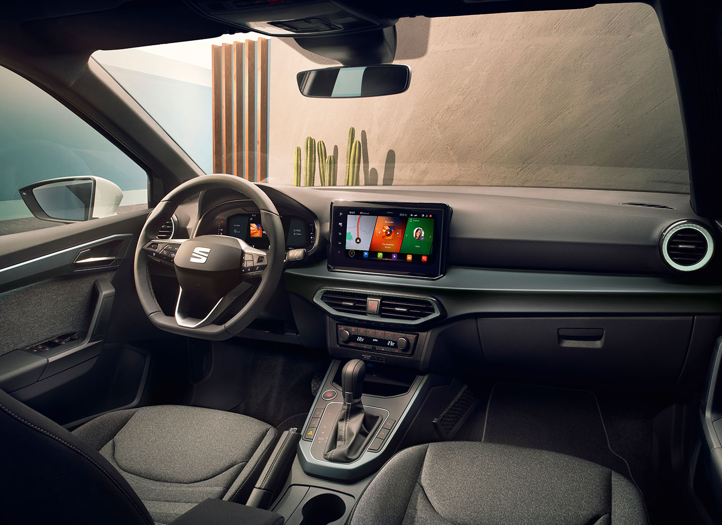 Fahrer mit einer Hand am Lenkrad, während er sein Smartphone benutzt, um OTA-Updates für das Infotainment-System des SEAT Arona zu installieren
