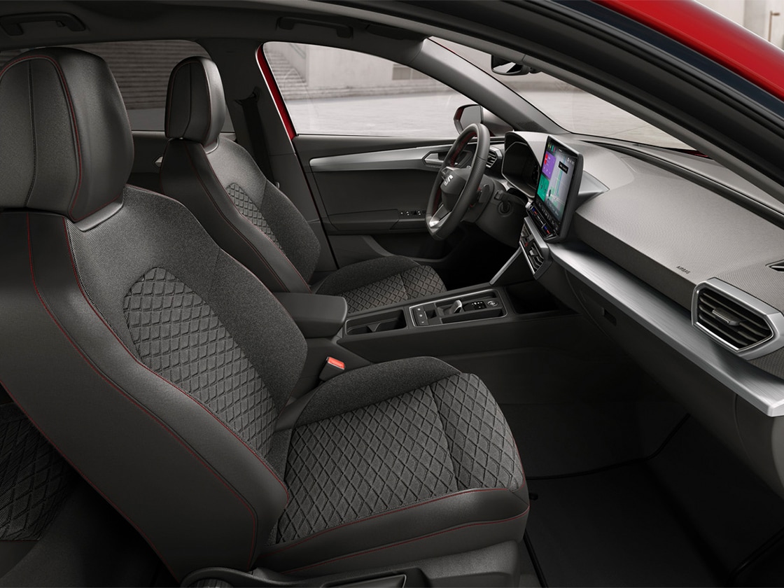 Innenansicht des SEAT Leon mit FR-Komfortsitzen aus Stoff, die ergonomische Unterstützung und stilvolles Design für eine komfortable Fahrt vereinen.