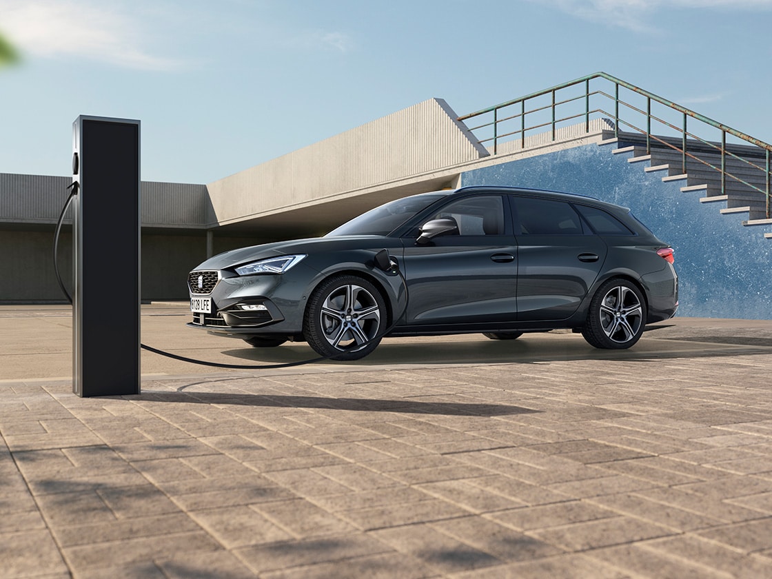 Der SEAT Leon Sportstourer steht an einer Ladesäule und lädt auf. 