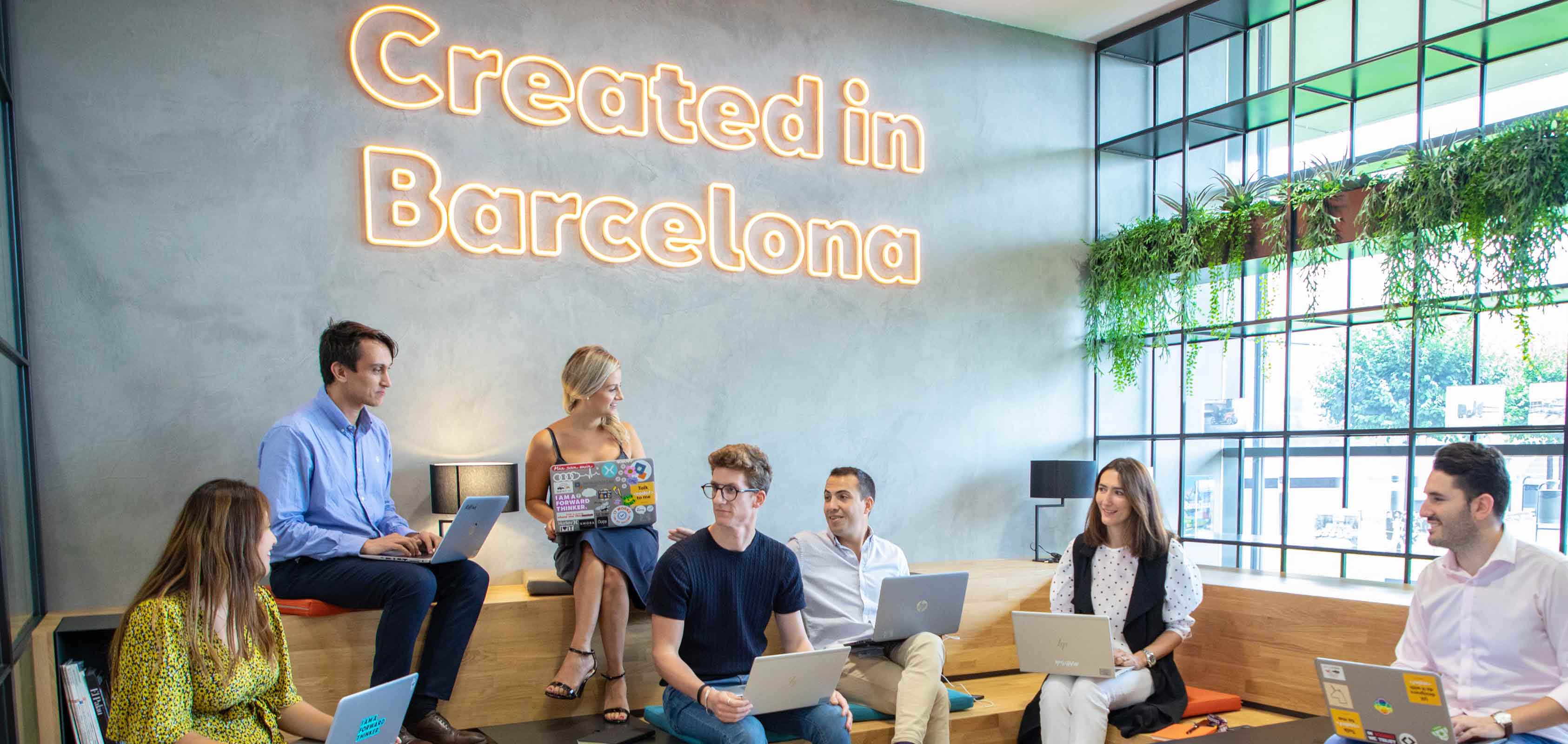 People gathered around a table with one man standing beside – SEAT Human Resources