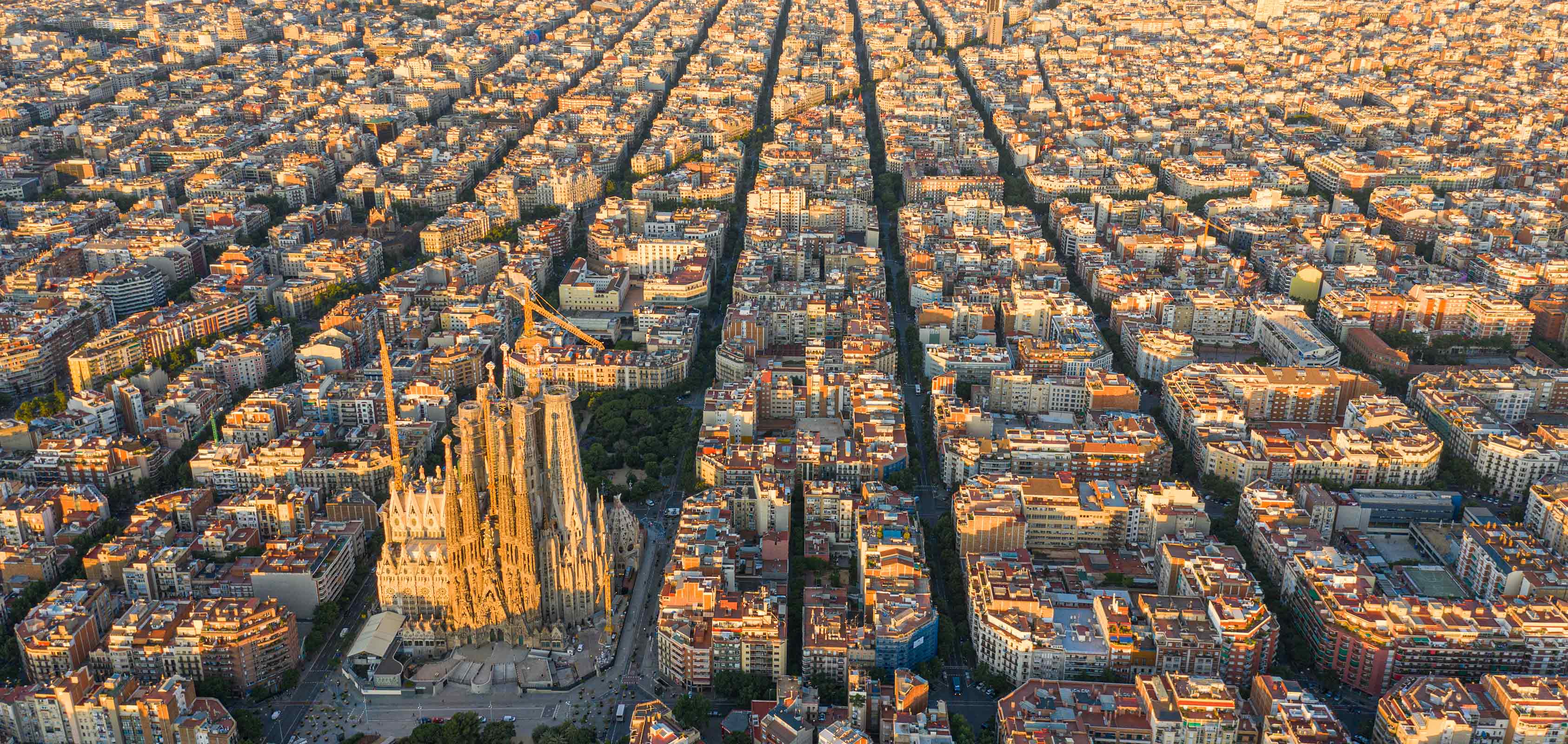 Luftaufnahme der Stadt Barcelona mit dem Stadtteil Eixample und der Kathedrale Sagrada Familia im Zentrum - SEAT kreatives Lebensgefühl | SEAT